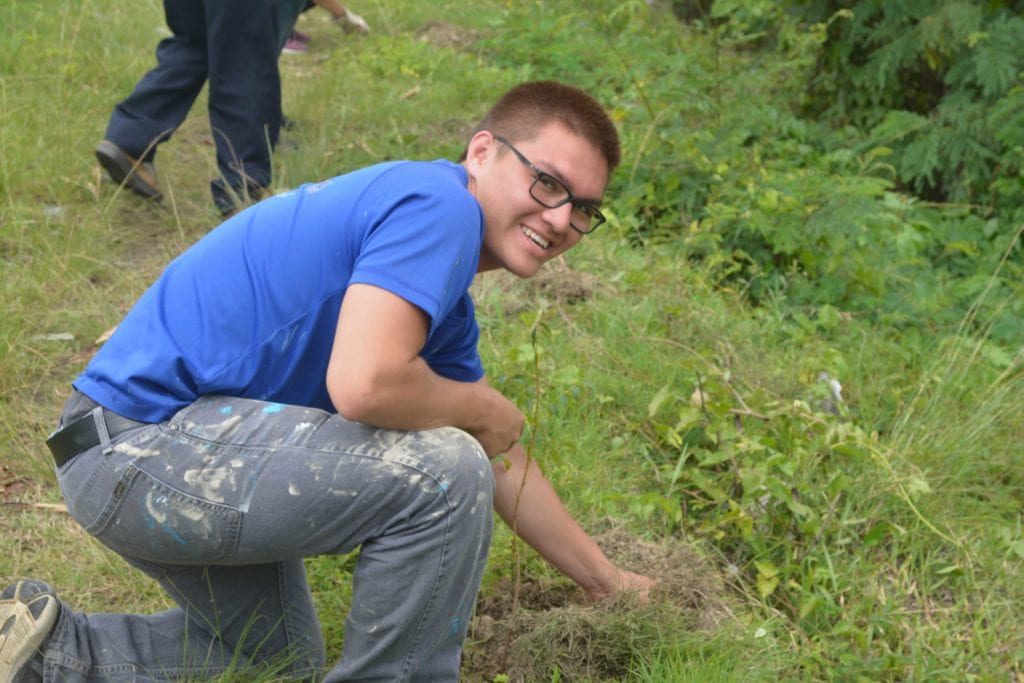 Student planting a tree in Dominican Republic.