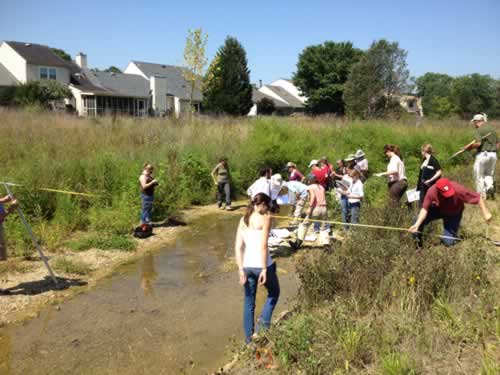 People walking next to a stream of water