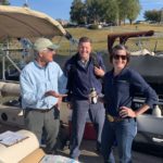 Randy Morris, Charles Denney and Dr. Andrea Ludwig talk on a pontoon boat