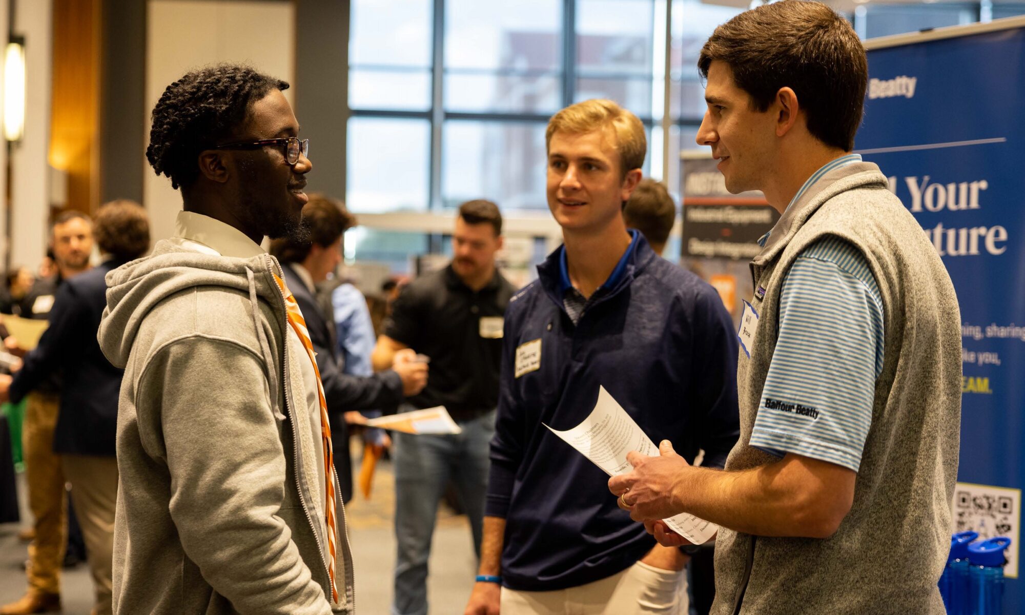 Student talking to two people from a potential employer from a company at a job fair