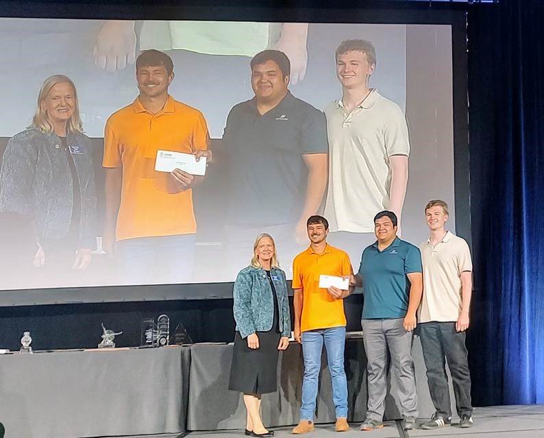 Dr. Dana Porter with Aaron Eimers, Julian Lee and Will Carey, who are being handed their prize at the 2024 ASABE conference